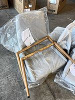 Chair seat wrapped in plastic with detached wooden legs