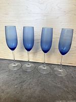 Four blue ombre champagne flutes standing side by side