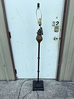 Full view of metal floor lamp standing upright