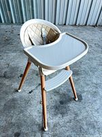 Front three-quarter view of high chair showing tray, seat, legs