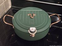 Overall view of green tempura pot with thermometer and lid