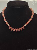 Front view of necklace on display bust showing pink sunstone, pearls and crystals