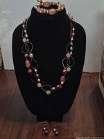 Full set on display: necklace, bracelet on bust, earrings below