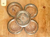 Top view of five coasters showing starburst centres and silver rims