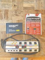 Monster Power HTS 1000 MKIII PowerCenter with manuals and spec sheet on table