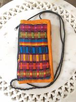 Front view of multicolor woven fabric pouch with neck cord