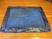 Full view of deflated blue/navy queen air mattress showing overall condition and pump control panel