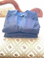 Stacked blazer, trousers and skirt folded on chair