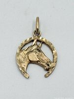 Front view of pendant showing horse head and horseshoe design