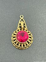 Front view of gold pendant with ruby stone