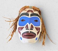 Front view of mask showing full painted design and cedar bark hair