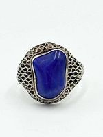Front view of sterling silver ring with blue lapis cabochon and filigree shoulders