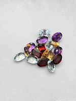 Front view of mixed oval gemstones showing colors and cuts
