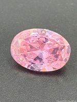 Top view of the pink oval-cut gemstone showing facets and color