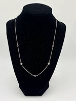 Full view of sterling silver station necklace on display bust