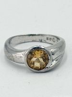Front view of sterling silver ring with round faceted citrine