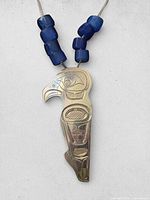 Close-up of pendant eagle carving and trade beads