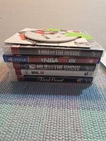 Stack of six PlayStation game cases with loose disc on top