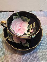 Teacup stacked on saucer showing floral design and gilt trim