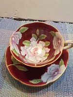 top view teacup on saucer showing red floral interior pattern white-pink roses