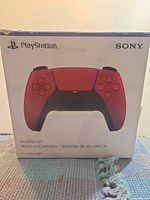 Front of boxed red Sony DualSense controller