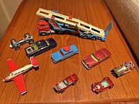 Group of all vehicles on wooden surface, showing transporter, cars, airplane