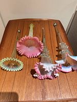 Four glass epergne trumpet vases on wood surface