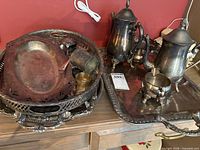 Overall view of tea set, trays and flatware on cabinet