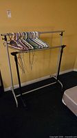 Full view of one garment rack with hangers on both bars