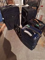 Group shot of four suitcases and folded luggage dolly