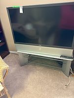 Front view of Akai rear-projection TV with stand and remote