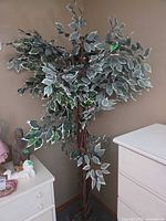 Full view of faux ficus tree between dressers