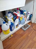 Shelf under sink filled with assorted cleaning products
