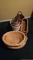 Group of assorted wicker and wood-slat baskets stacked together