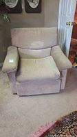 Front view of beige corduroy armchair showing seat, back, arms and wear