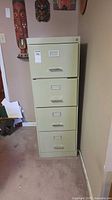 Front view of beige four-drawer metal filing cabinet