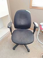 Front view of black fabric office chair showing seat, backrest, armrests and base