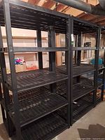 Two black plastic shelving units side by side