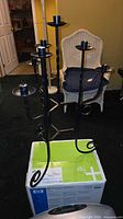 Full view of black wrought iron five-arm floor candelabra on box