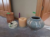 Group shot showing vase, angel figurine, two pillar candles, taper candle