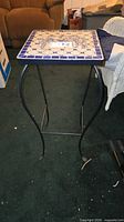 Full view of side table showing tile top and iron frame