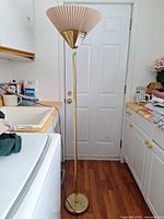 Full view of brass torchiere lamp with pleated shade