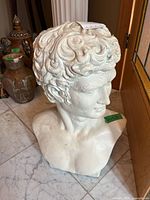 Front three-quarter view of white plaster David-style bust