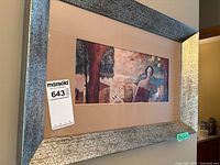 Full view of framed print on wall with silver wood frame and mat