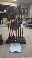 Front view of full croquet set on stand showing mallets, balls and wickets