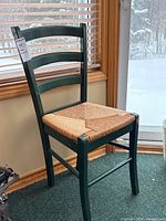 Full view of green ladder back dining chair by window