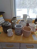 Group shot of all nine ceramic and stoneware pieces on countertop