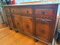 Front view showing overall form, drawers, doors, hardware, and ball-and-claw feet