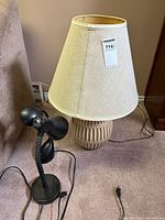 Wood table lamp with shade beside black gooseneck desk lamp