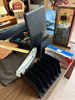 Overall lot showing file sorter, CD clock display, briefcase of tools, rolling ruler box and folio